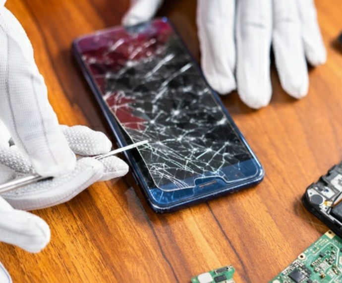 Professional technician in white gloves performing a precision screen replacement on a cracked smartphone at iMicro Repairs in Naples, FL.